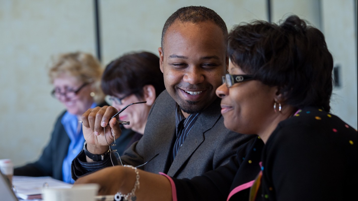 two people smiling at a bargaining table 