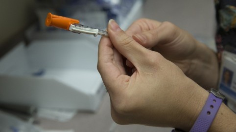 A pair of hands holding a medical needle