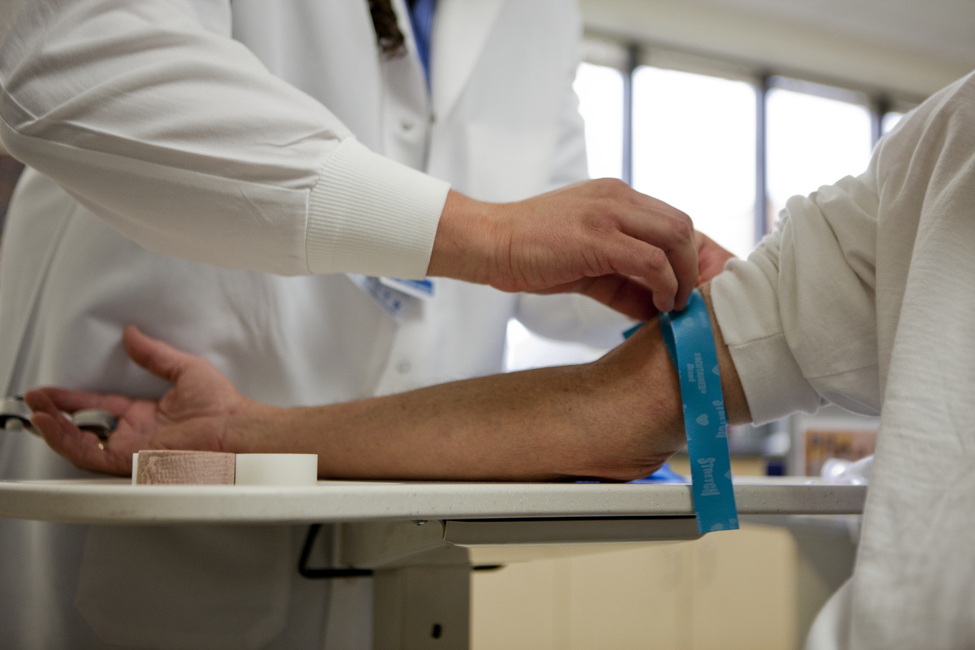 A provider preparing a patient's arm for a blood draw 